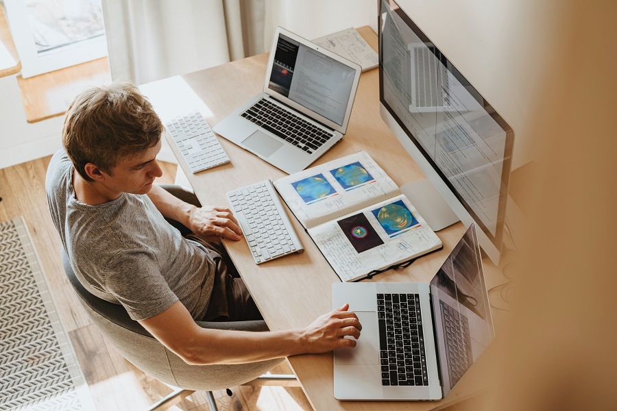 Man working at multiple computer screens